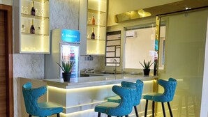 A modern bar area with a marble countertop, blue bar stools, and ambient lighting. - Double D Luxury Apartments (Abuja)