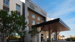 A modern hotel with a flat roof, large windows, and a covered entrance area.