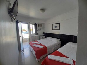 A hotel room with two beds, a TV, a window, and a view of the outside. - Escuna Hotel Pousada (Maceió)