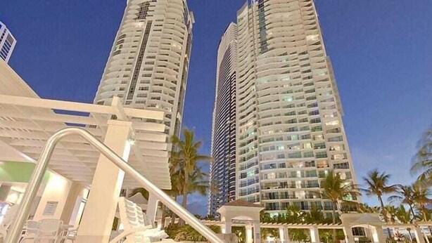 A hotel with two tall buildings, a pool area, and palm trees. - Chevron Renaissance Private room Lvl16 (Surfers Paradise)