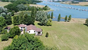 Een groot huis met een ruime tuin en uitzicht op een rivier.