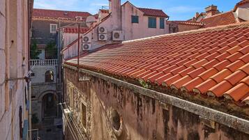 Una calle estrecha con edificios que tienen techos de tejas rojas y ventanas arqueadas.