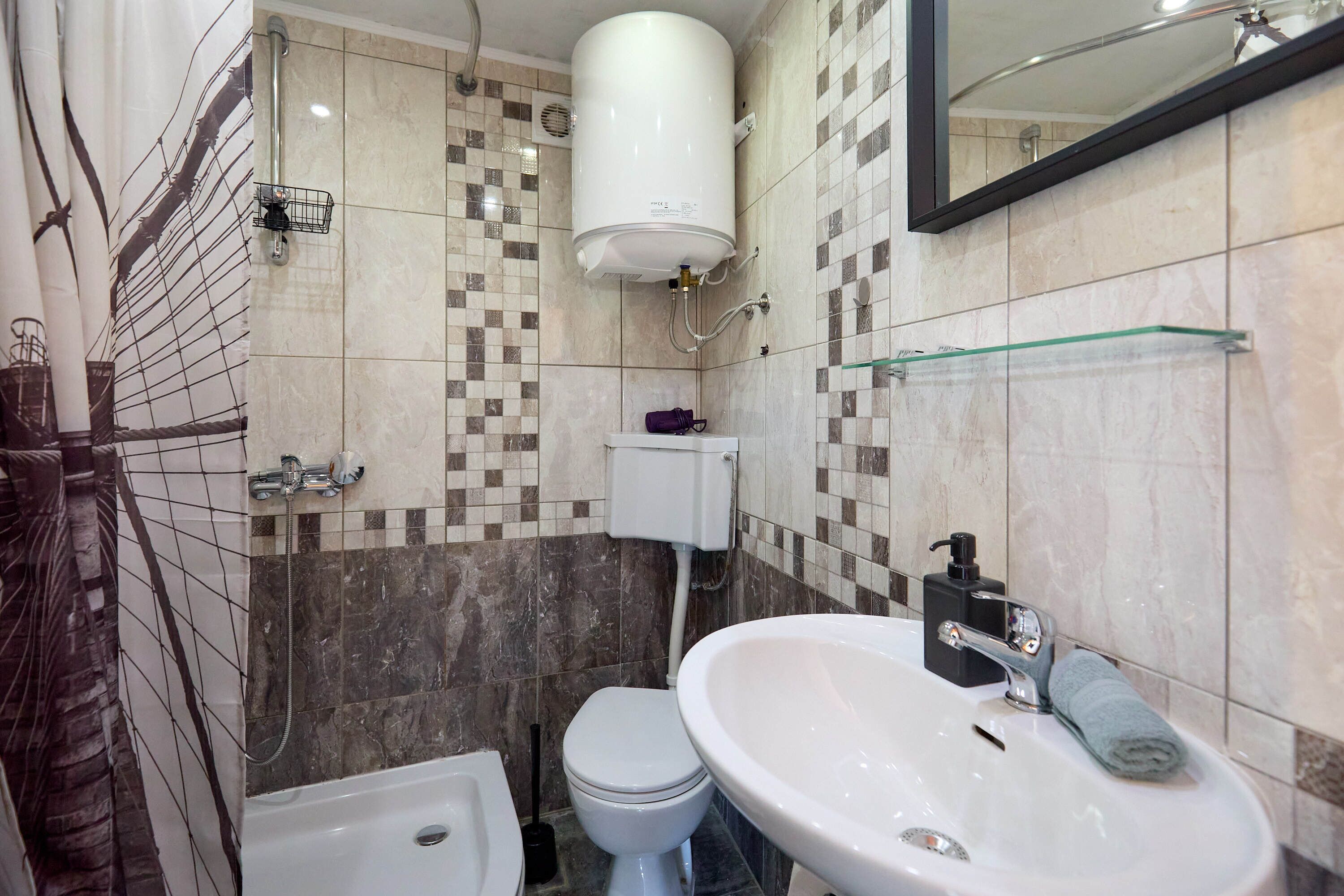 Un baño con inodoro, bidé, lavamanos y zona de ducha.