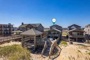 A beachfront property with multiple wooden buildings, a gazebo, and a swimming pool.