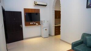 A compact living space with a kitchenette, a flat-screen TV, and a small refrigerator. - Laylati Al Nagah (Riyadh)