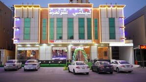 A building with a sign for 'service apartments' and multiple cars parked in front. - Laylati Al Nagah (Riyadh)