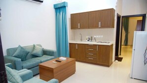 A compact living space with a kitchenette, a sofa set, and a coffee table. - Laylati Al Nagah (Riyadh)