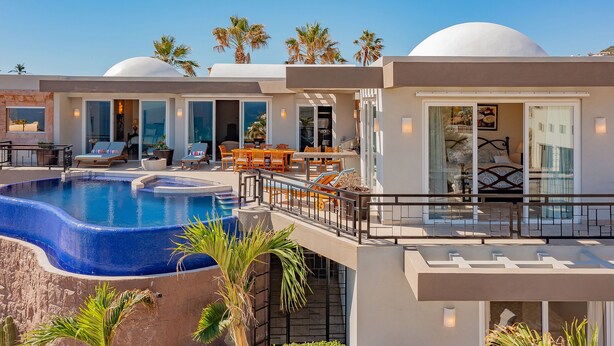 A modern resort with a large swimming pool, outdoor seating, and palm trees. - Pedregal Luxury Villa w/ Infinity Pool, Hot Tub, Walk to Beach & Sunrise Views (Cabo San Lucas)