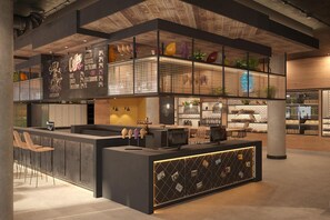Un café moderne doté d’un comptoir, d’un espace salon et d’éléments décoratifs tels que des plantes et des œuvres d’art.