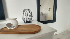 A white countertop with a white vase and a wooden tray. - Studio Cosy Le 12 (Châlons-en-Champagne)