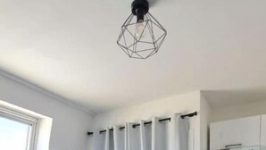 A modern kitchen with white cabinets and a built-in oven. - Studio Cosy Le 12 (Châlons-en-Champagne)