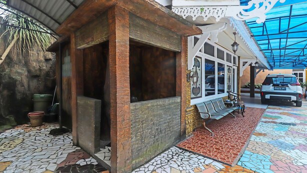 Un bâtiment de style rustique, doté d’un sol carrelé, d’un petit porche et d’un espace détente abrité.