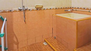 Une salle de bain avec une douche, une baignoire et des toilettes.