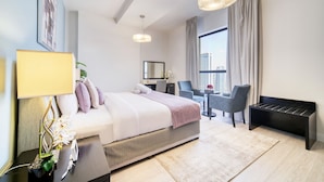 A modern hotel room with a bed, bedside table, lamp, and a view of the city through the window.