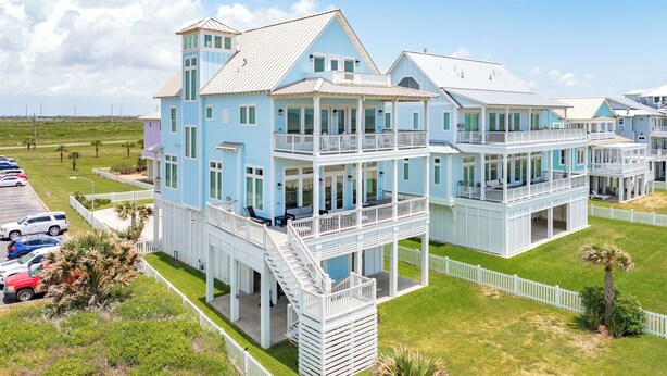 A large, multi-story beachfront property with multiple balconies and a covered outdoor area. - Private Beachfront Home w/ 5 Decks, 3 Suites, Fenced Yard in Beachside Village (Galveston)