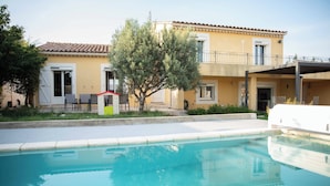 Un immeuble de deux étages avec une piscine devant.