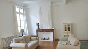 Une pièce spacieuse avec deux canapés blancs, une cheminée en bois et un meuble.