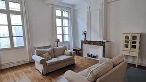 Un salon spacieux avec deux canapés, une cheminée et un meuble.