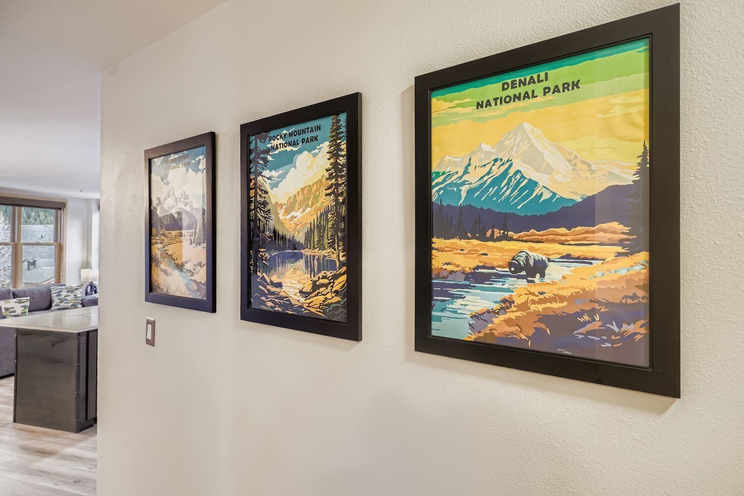 Trois affiches encadrées sont accrochées au mur, chacune représentant un parc national différent.