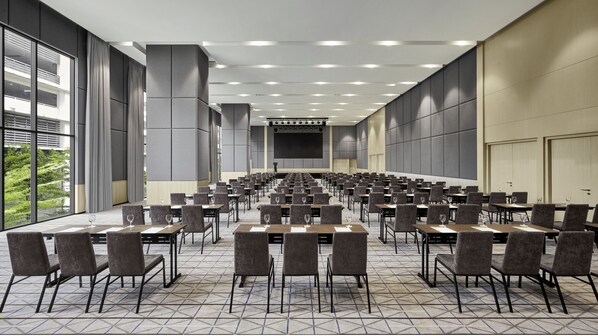 A large conference room with rows of tables and chairs, a stage at the front, and large windows on one side. - Hyatt Place Kuala Lumpur Bukit Jalil (Kuala Lumpur)