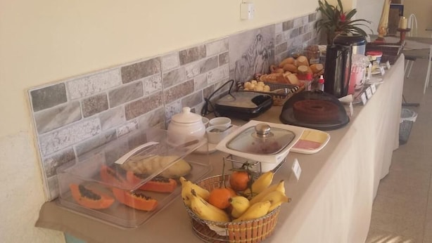 Un bufé de desayuno con diversas frutas, pasteles y bebidas.