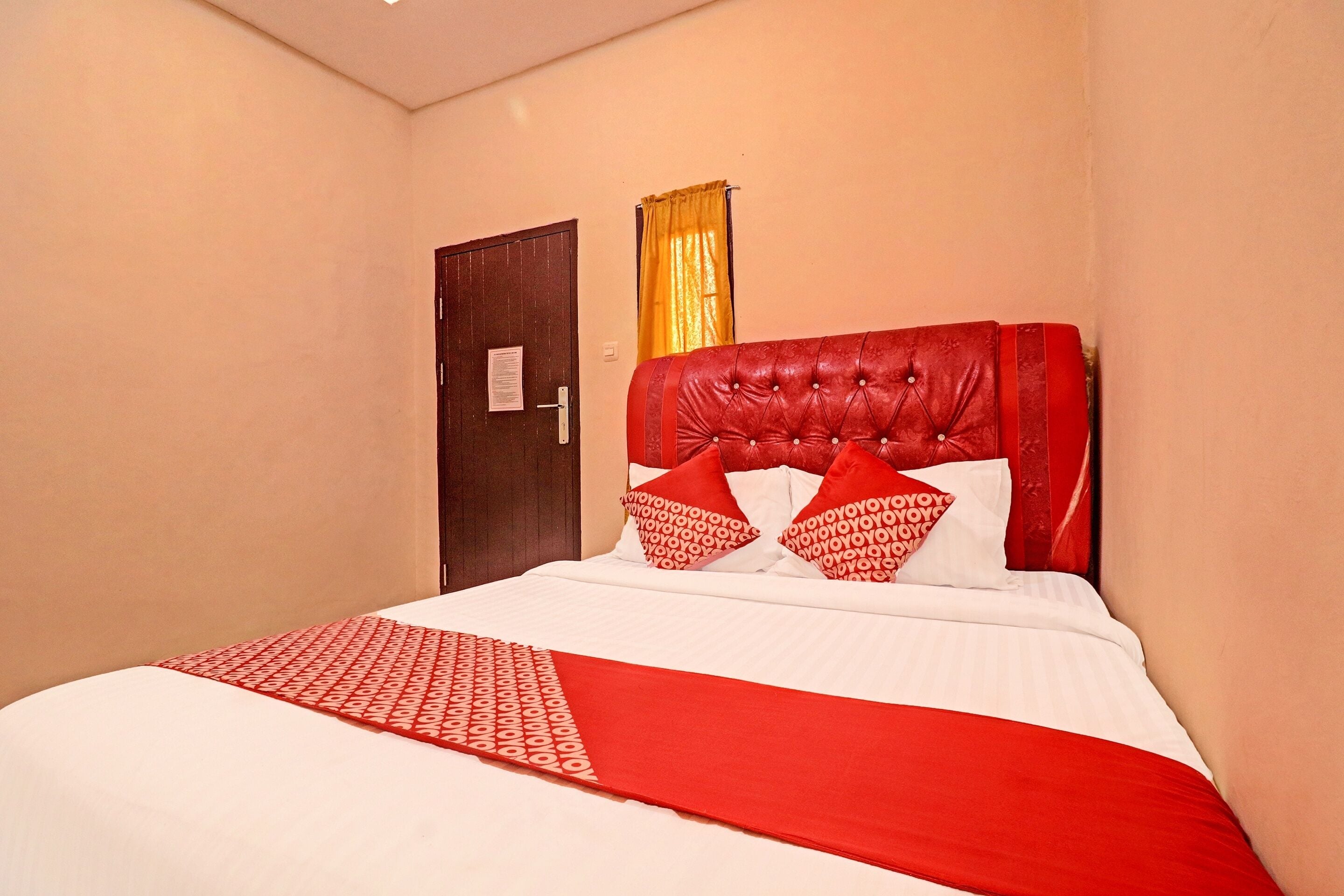 Ein Hotelzimmer mit Bett, Tür und Vorhang.