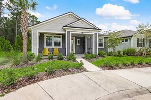 Situated in a quiet suburban neighborhood, this house features a gabled roof and a charming front porch.