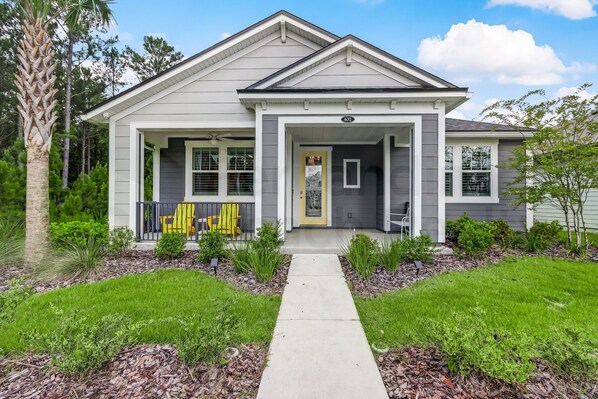 Stunning two-story home with a central entrance, flanked by windows and a charming porch.