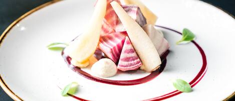 A plate with a dessert consisting of fruit and cream.