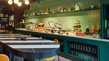 Un restaurante con una barra alargada, varias zonas de asientos y una amplia variedad de alimentos y bebidas a la vista.