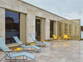 Una terraza con tumbonas y un cerramiento de madera.