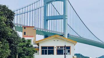 A large suspension bridge with a building under it.