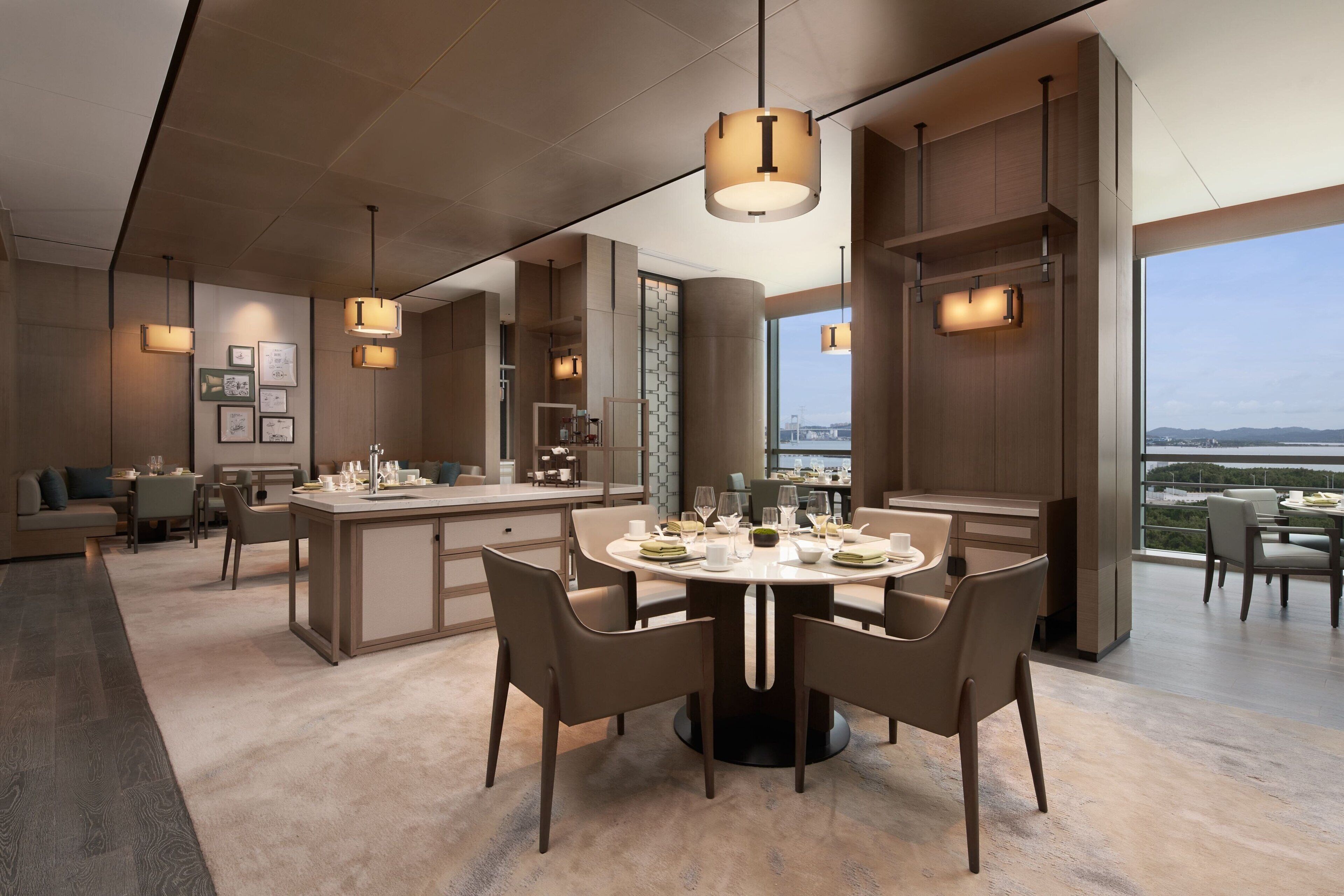 A modern dining area with a round table, chairs, and pendant lighting.