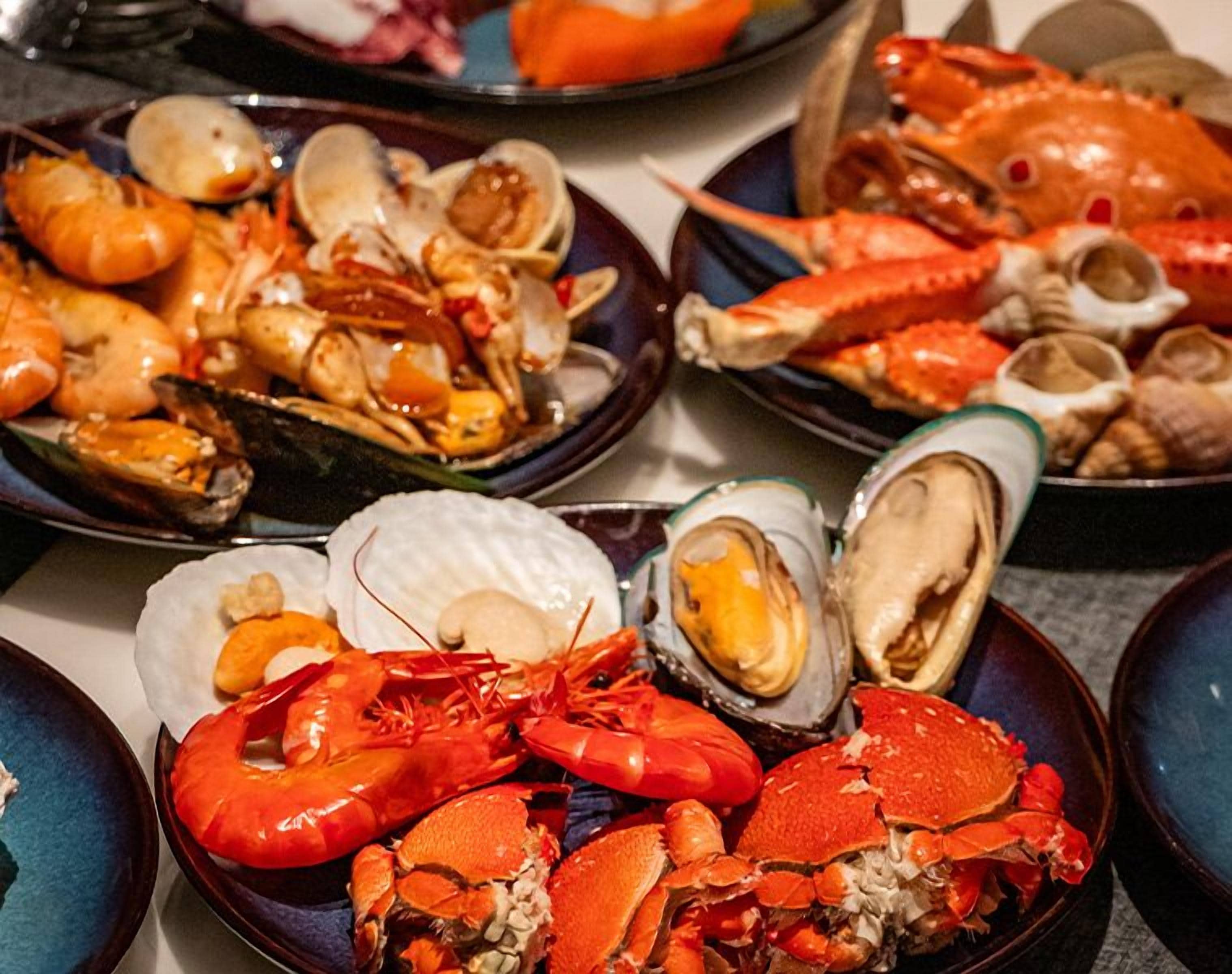 A variety of seafood dishes including lobsters, crabs, and clams.