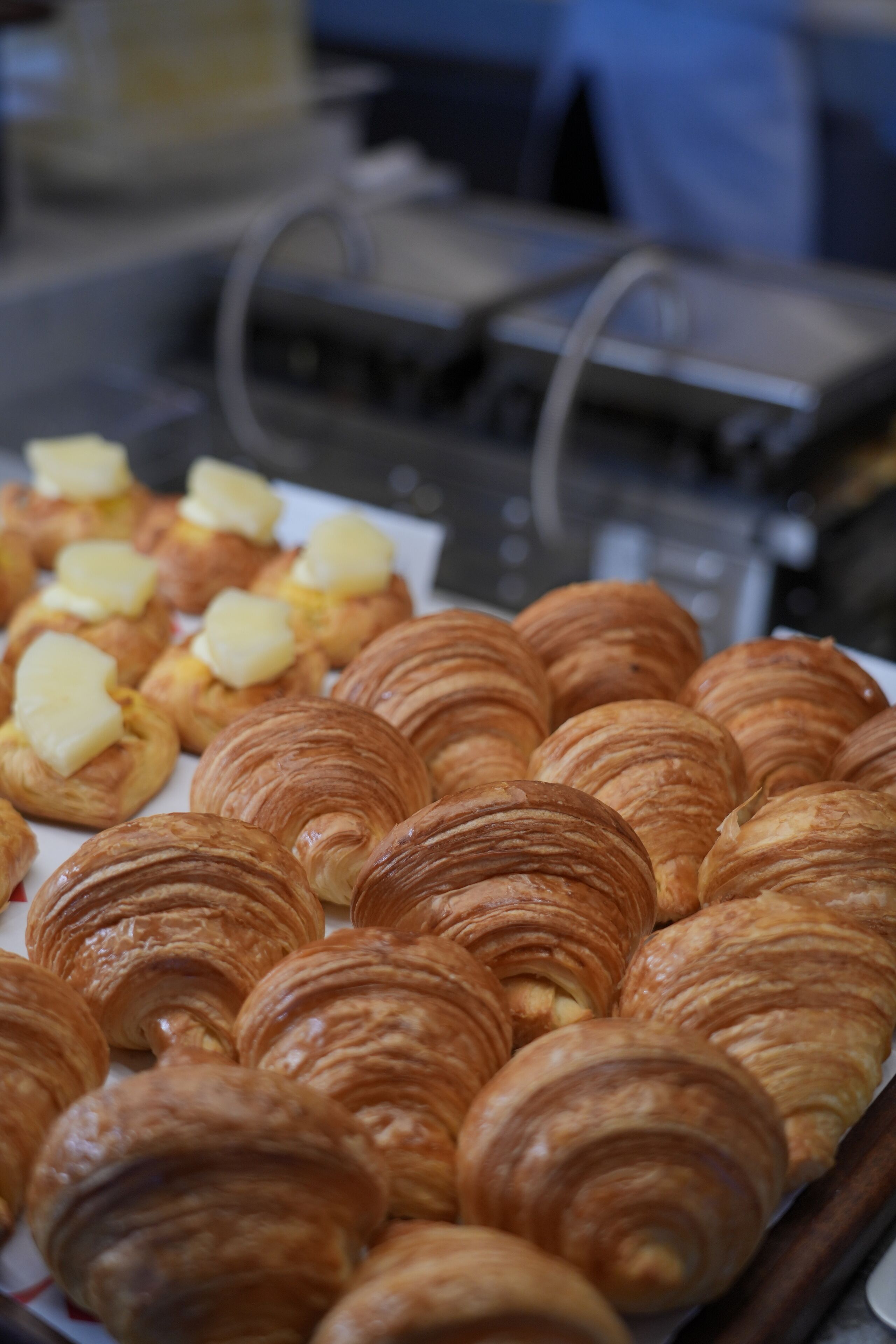 Una bandeja con varios pasteles, incluyendo croissants y bollos de mantequilla.