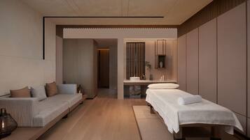 Relax in a serene space with a neatly made bed, comfortable sofa, and a small table with a lamp.