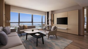Una sala de estar moderna con un sofá, sillones, una mesa de centro y un televisor montado en la pared.