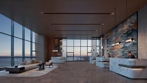 Un vestíbulo amplio con ventanas grandes, una recepción y zonas de estar.