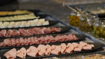 A buffet with various meats and fish arranged on platters.