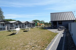A campground with mobile homes, picnic tables, and a playground.