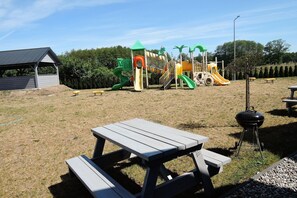 Enjoy family gatherings and outdoor dining in this outdoor space with a play structure, picnic tables, and barbecue grill.
