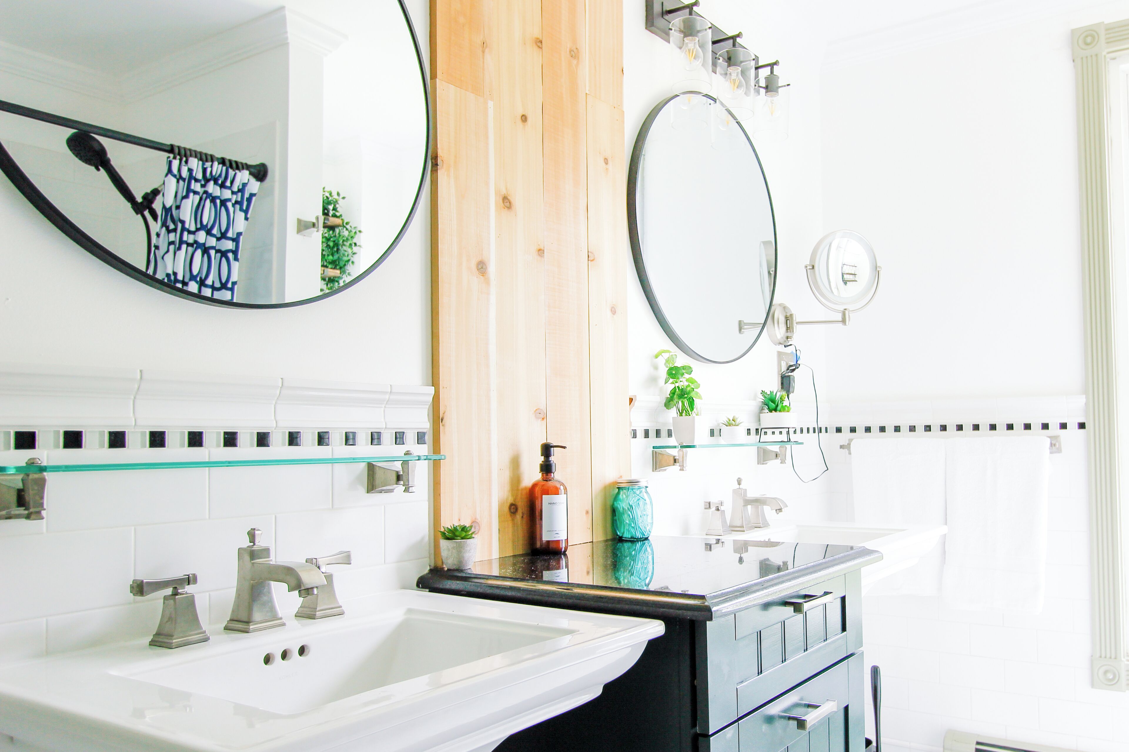 Une salle de bain moderne avec deux vasques, un grand miroir et un élément décoratif en bois.