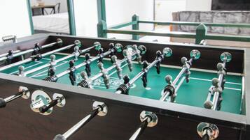 A foosball table with a green playing surface and metal rods.