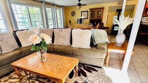 A living room with a sofa, coffee table, and patterned rug. - Beautiful and private lakefront home on the sandy shores of South Twin Lake (Indian Purchase Township)