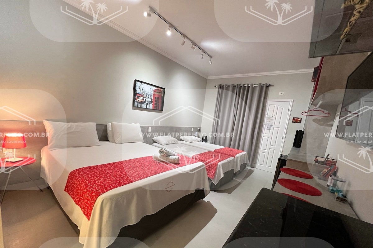 A hotel room with two beds, a desk, and a bathroom.
