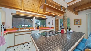 Una cocina moderna con vigas de madera, un ventanal grande y un revoque de azulejos.