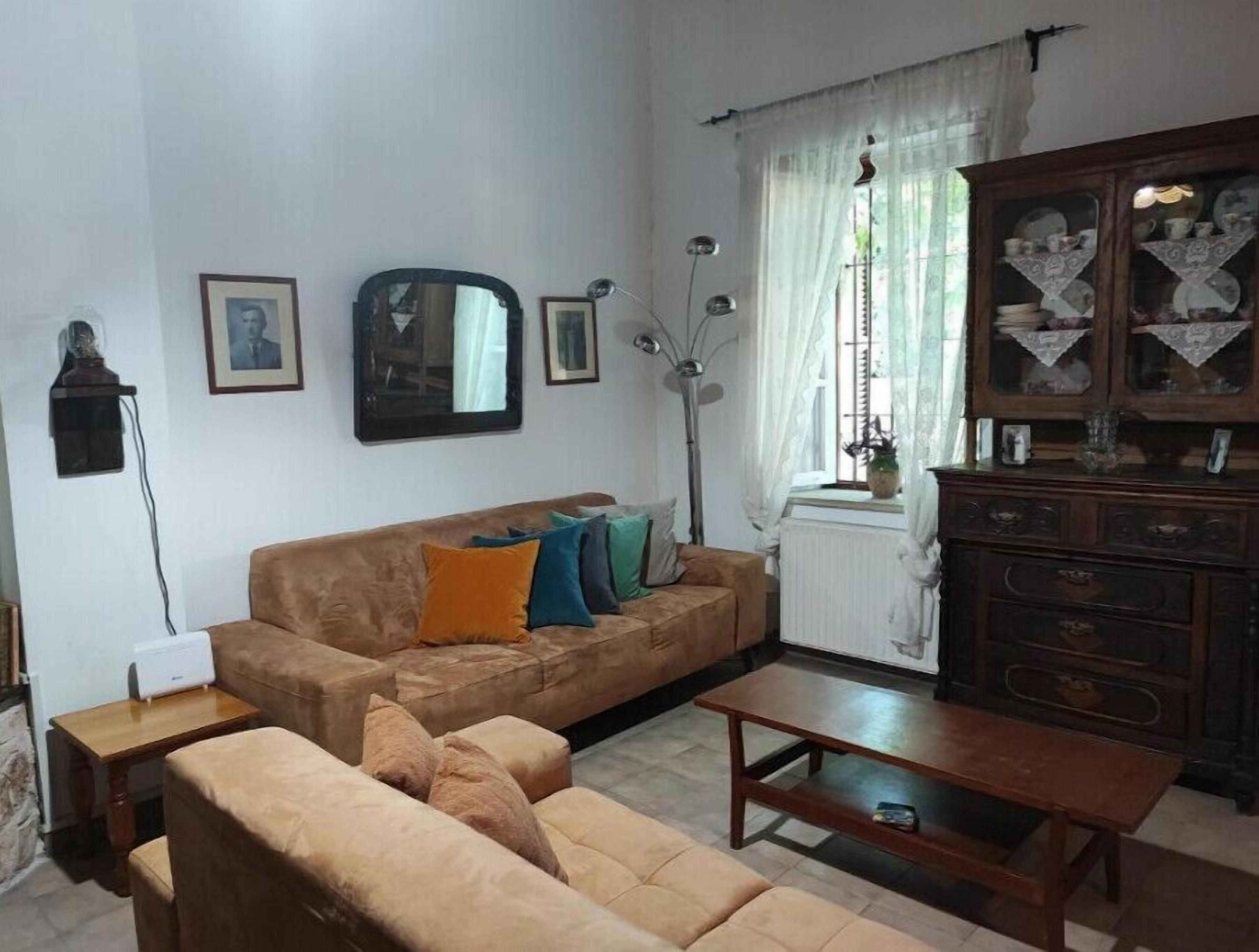 A living room with a brown sofa, a wooden coffee table, and a cabinet with glass doors.