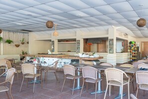 A spacious outdoor dining area with wicker chairs and a central bar. - BCMA Muro Alto (Ipojuca)