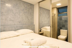 A hotel room with a bed, a bathroom with a toilet, and a shower area. - BCMA Muro Alto (Ipojuca)