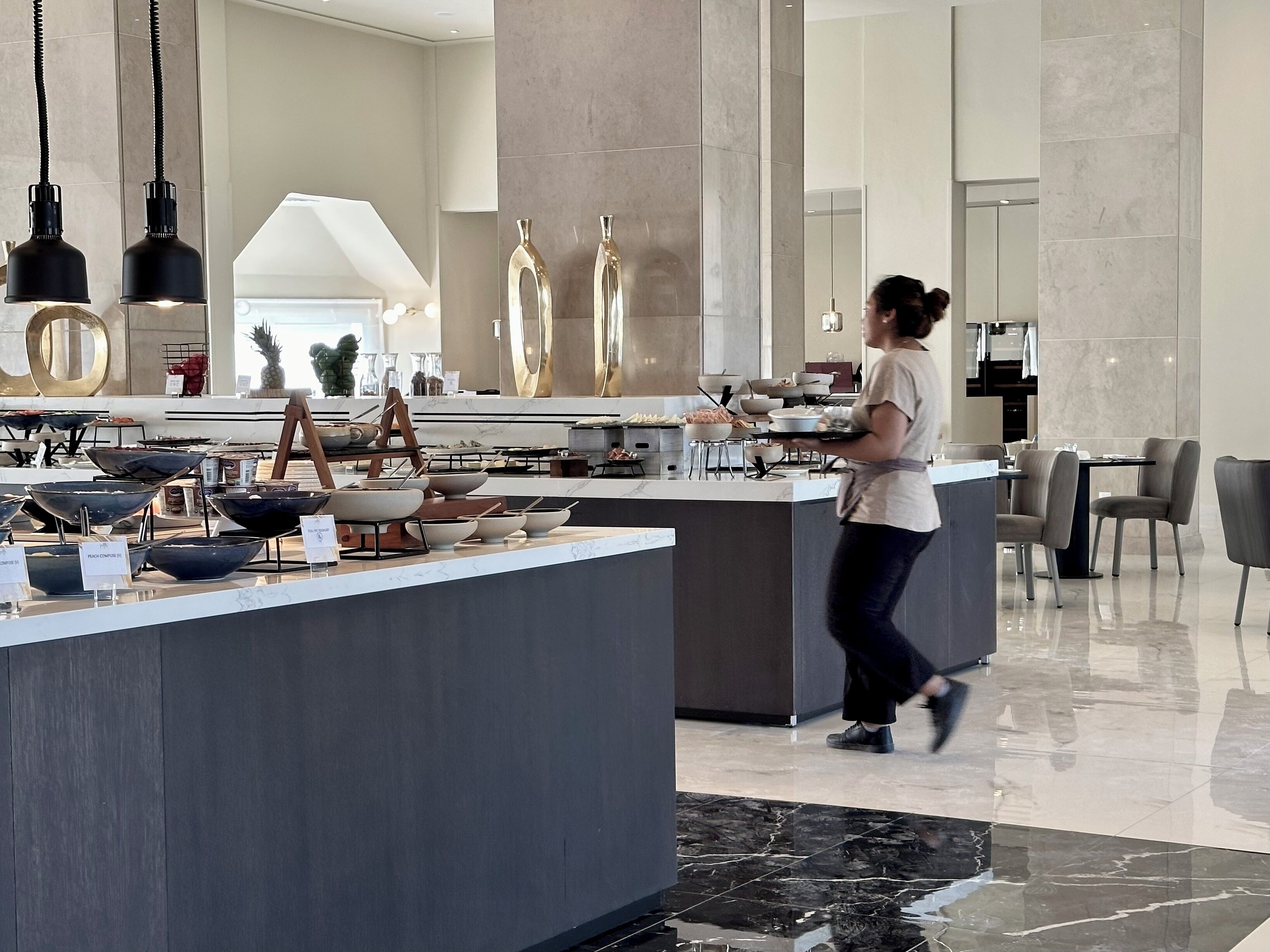 A modern kitchen with a central island, stainless steel appliances, and a variety of cookware displayed on the counter.